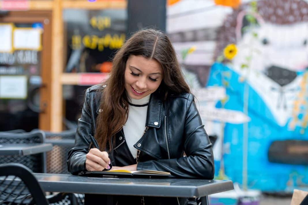 Jeune femme heureuse de rédiger une lettre de motivation pour un stage