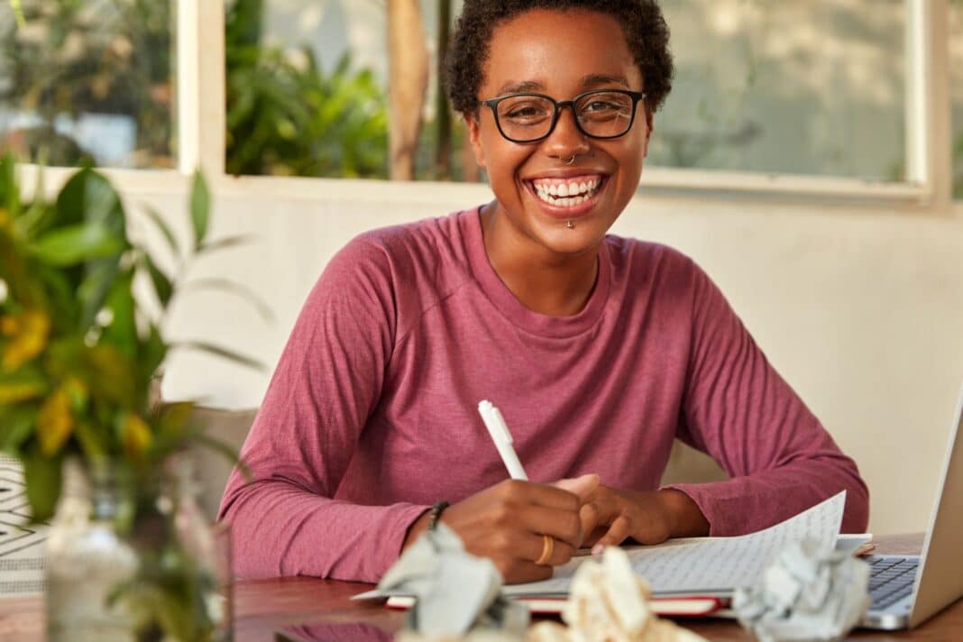 Etudiante heureuse de rédiger sa lettre de motivation pour son alternance