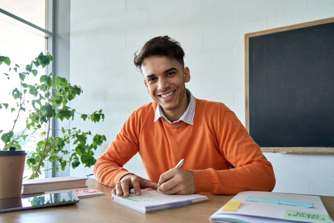 Professeur souriant en écrivant sa lettre de motivation pour une agrégation par liste d'aptitude