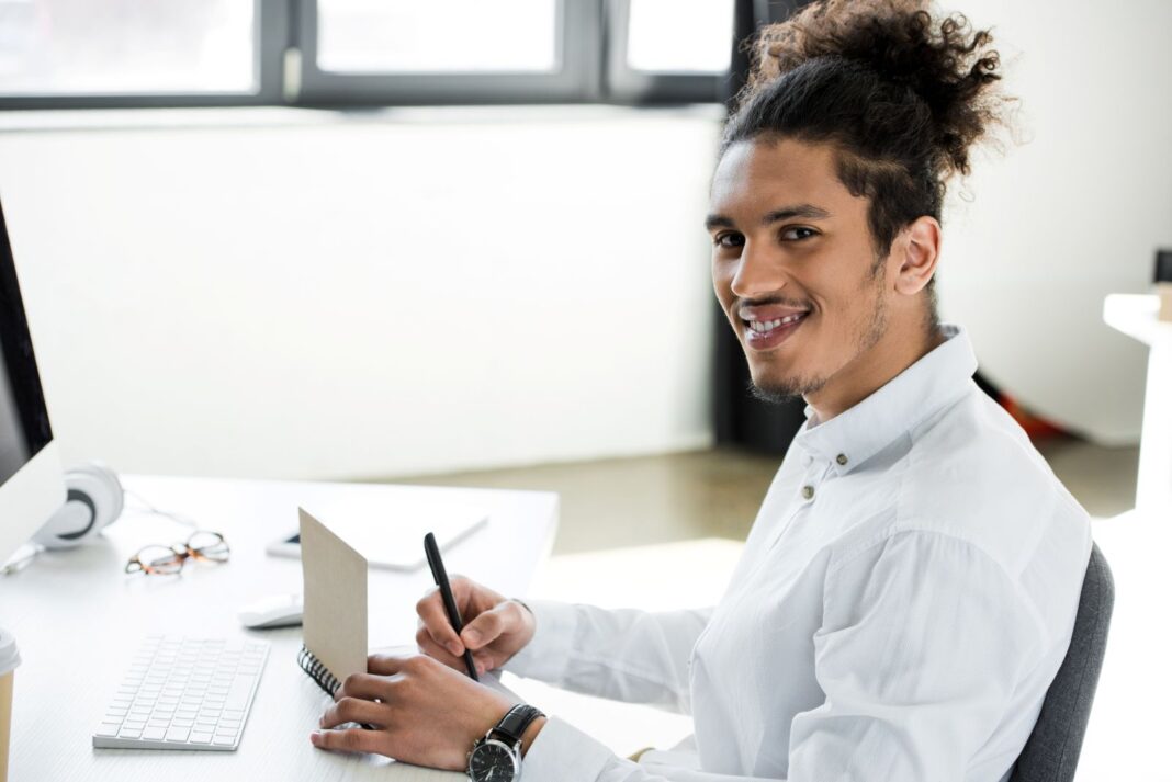 Etudiant satisfait d'écrire une lettre de motivation pour une demande d'apprentissage