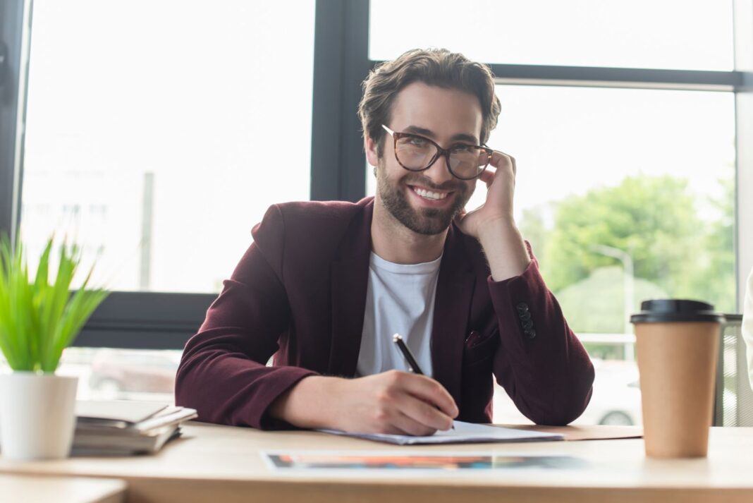 Homme satisfait d'écrire une lettre de motivation pour le journalisme
