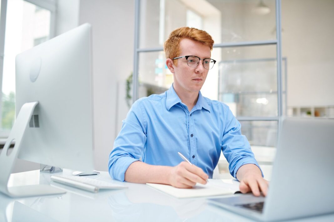 Jeune étudiant satisfait d'écrire sa lettre de motivation pour un stage en CAP