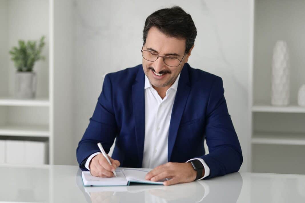 Homme satisfait d'écrire une lettre de motivation pour être directeur administratif