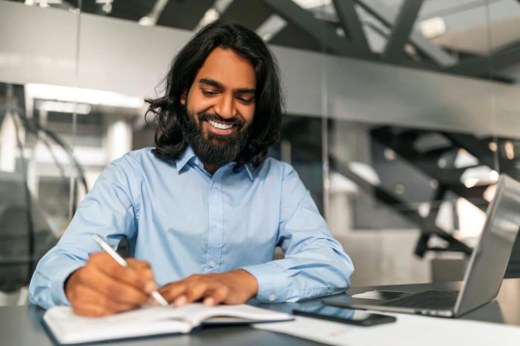 Homme heureux de rédiger sa lettre de motivation pour la naturalisation