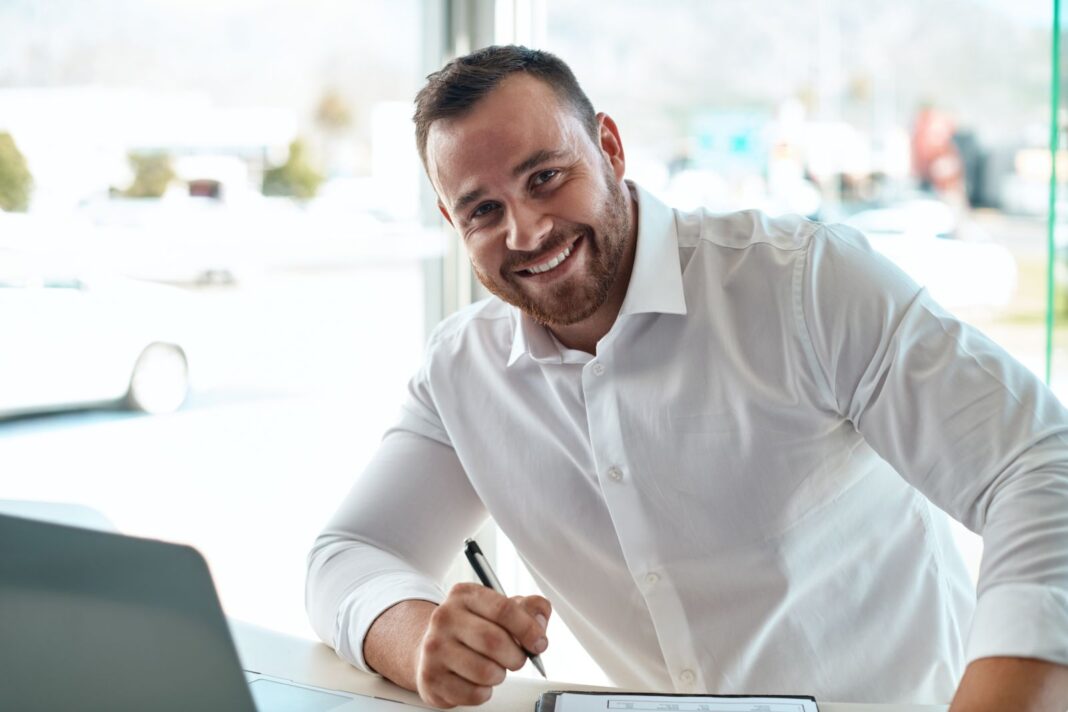 Homme heureux de rédiger une lettre de motivation pour être assistant commercial