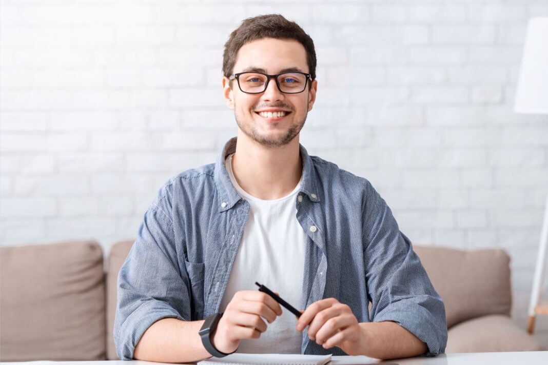 Etudiant satisfait d'écrire une lettre de motivation pour un contrat pro