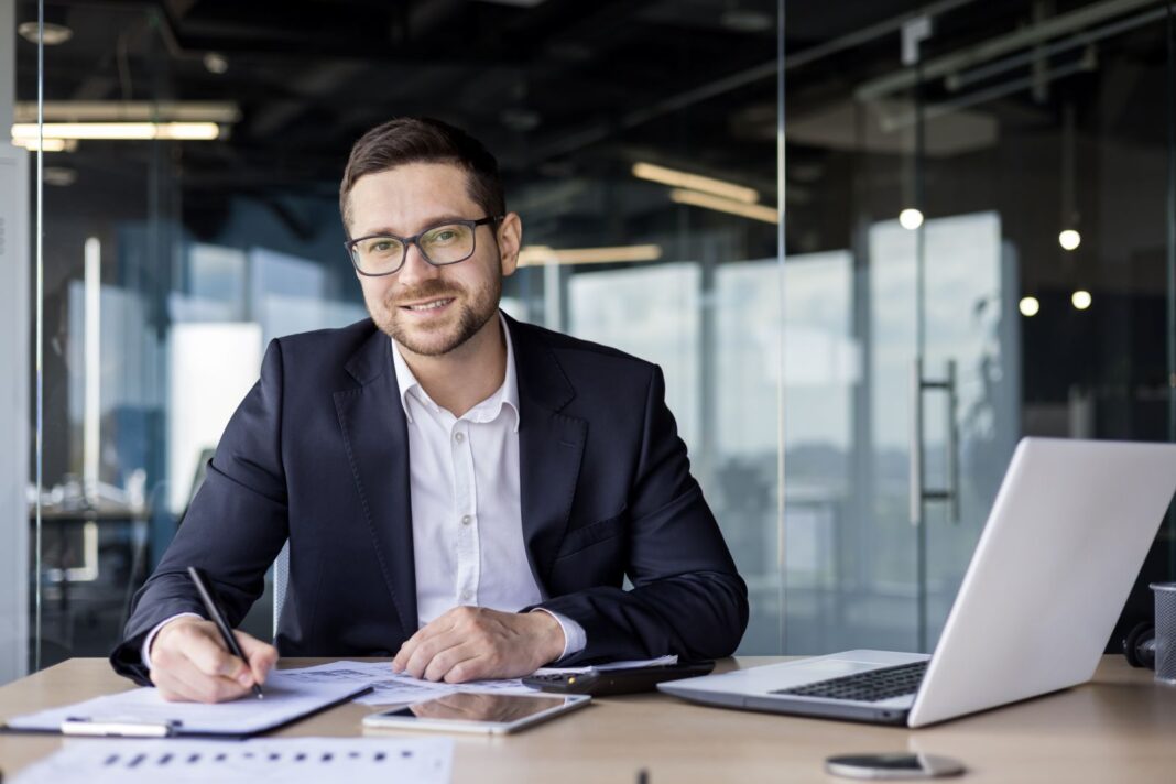 Homme d'affaire heureux de rédiger une lettre de motivation en finance