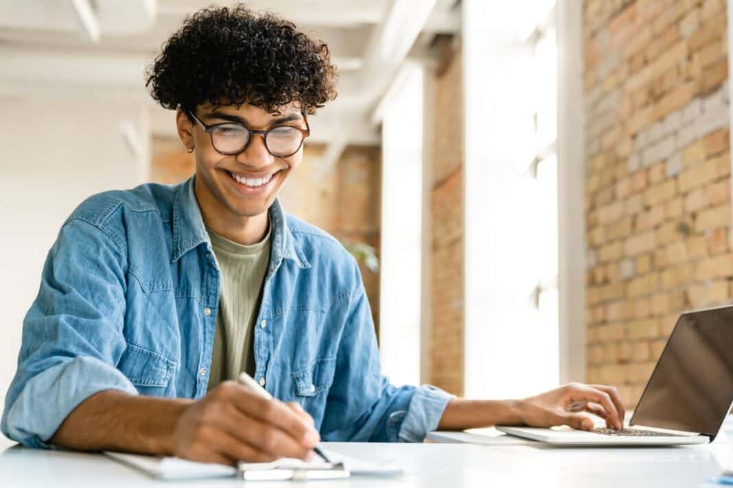 Etudiant satisfait d'écrire sa lettre de motivation pour une école de commerce