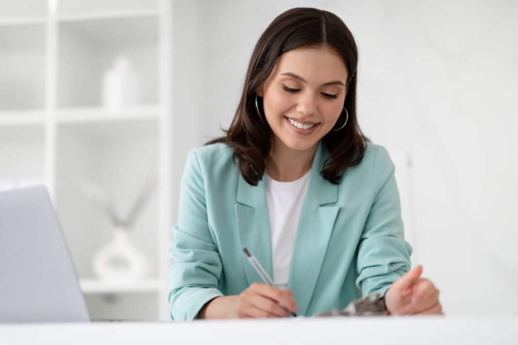 Jeune femme heureuse de rédiger une lettre de motivation pour un emploi en mairie