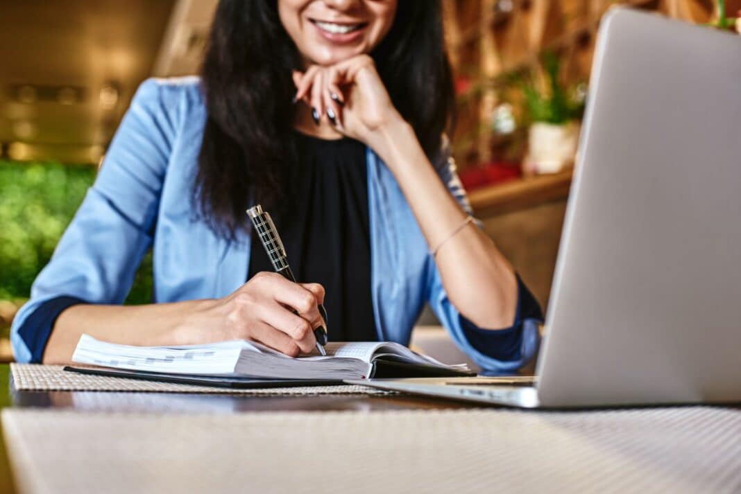 Femme heureuse de préparer sa lettre de motivation pour un emploi dans la vente